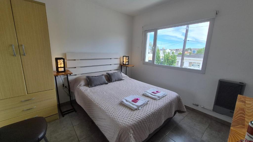 ein Schlafzimmer mit einem Bett mit zwei Handtüchern darauf in der Unterkunft Departamento familiar in Caleta Olivia