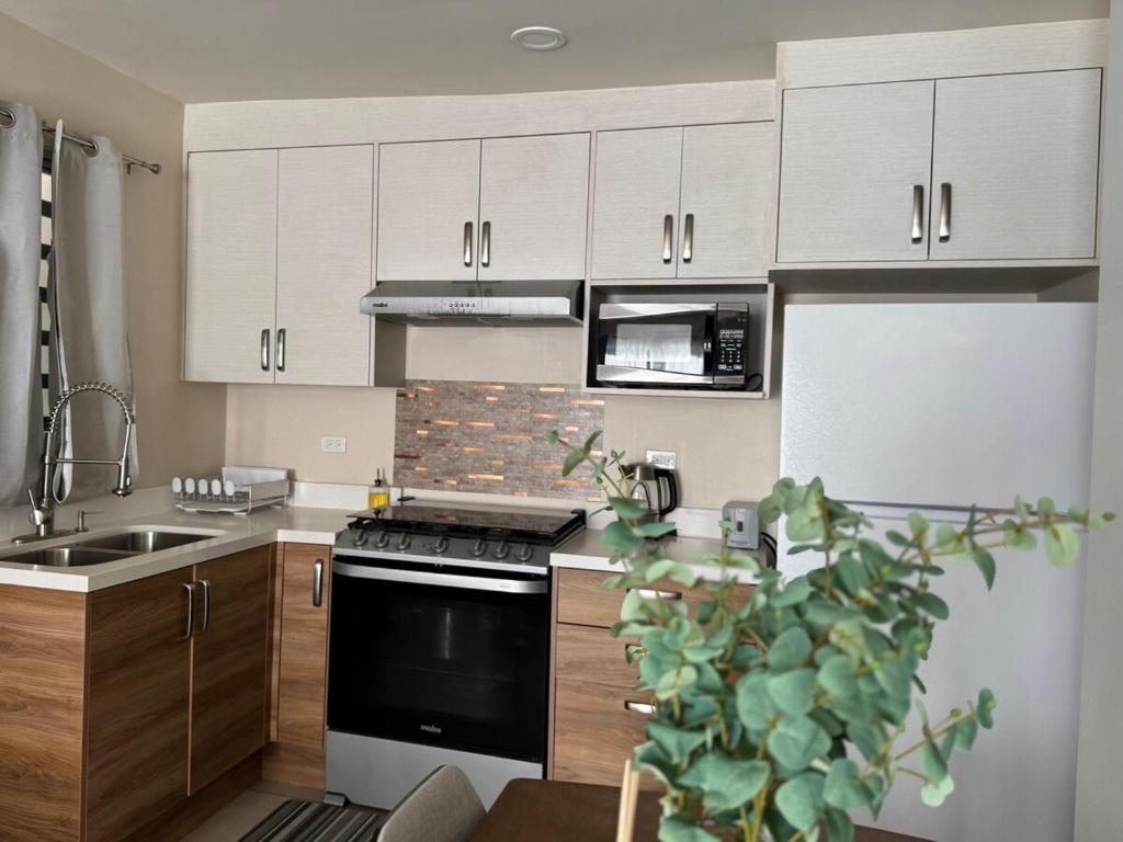 a kitchen with white cabinets and a stove top oven at Amar Apartment - 24 hour security, Comfort in Tijuana