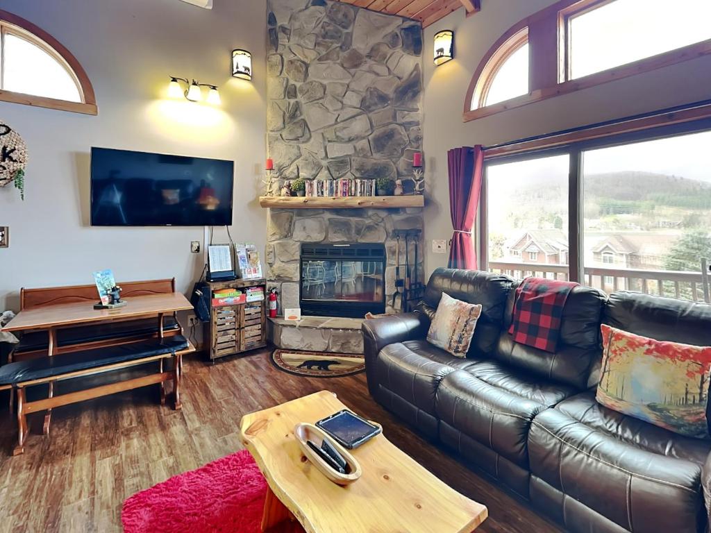 a living room with a leather couch and a fireplace at Our Happy Place in McHenry