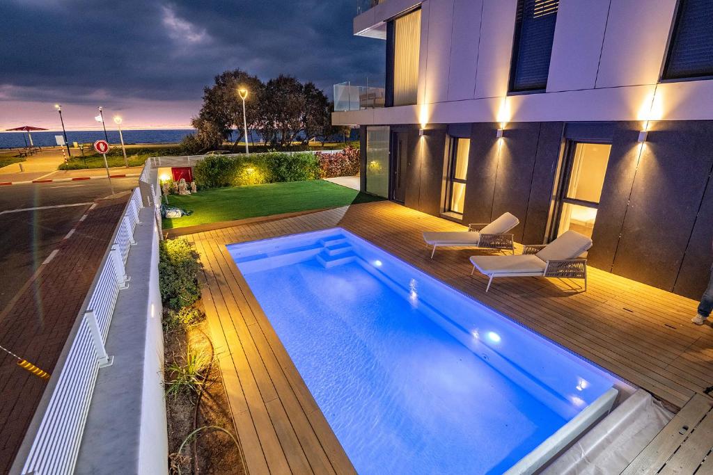 une piscine dans l'arrière-cour d'une maison dans l'établissement מיקונוס על הים נהריה, à Nahariya