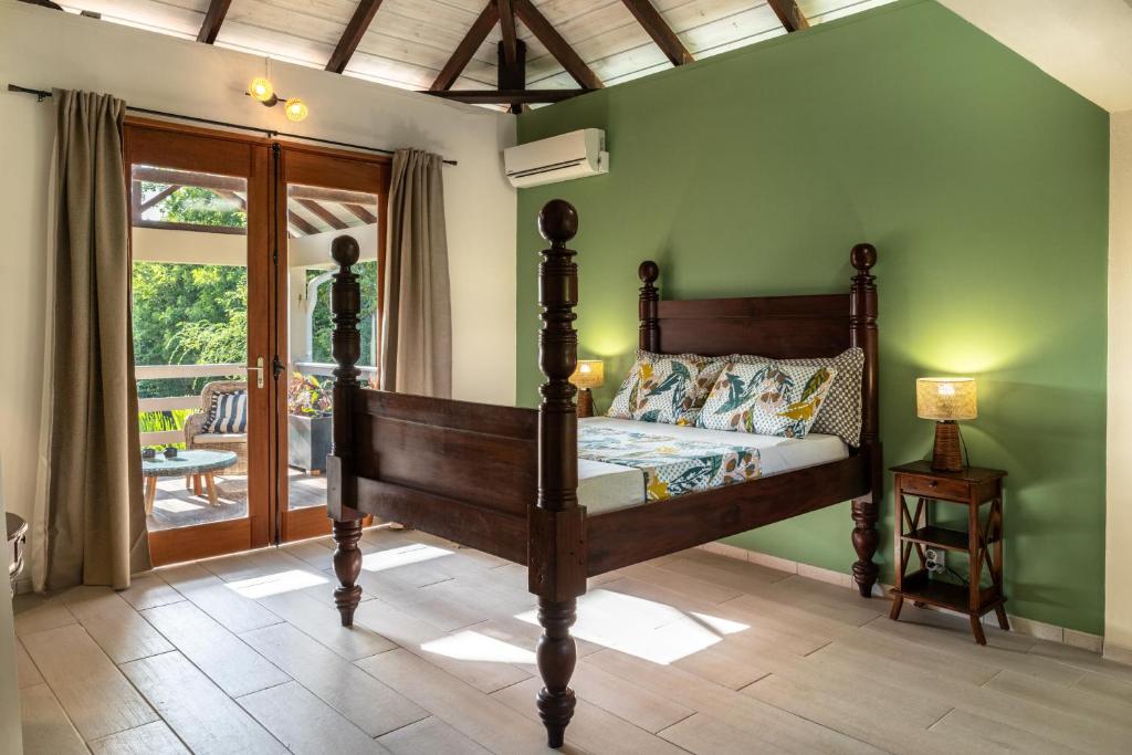 a bedroom with a bed and a green wall at Maison Remissis in Sainte-Luce
