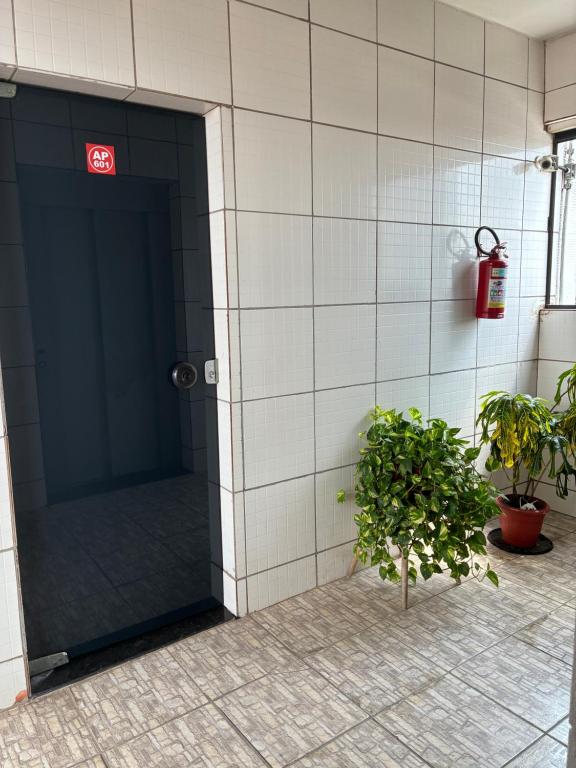 a bathroom stall with a door and a potted plant at Apartamento Flat em Belém in Belém
