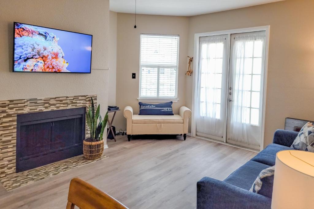 帕德雷岛Beach Club - Ocean Breeze Retreat – Island Condo的带壁炉和平板电视的客厅