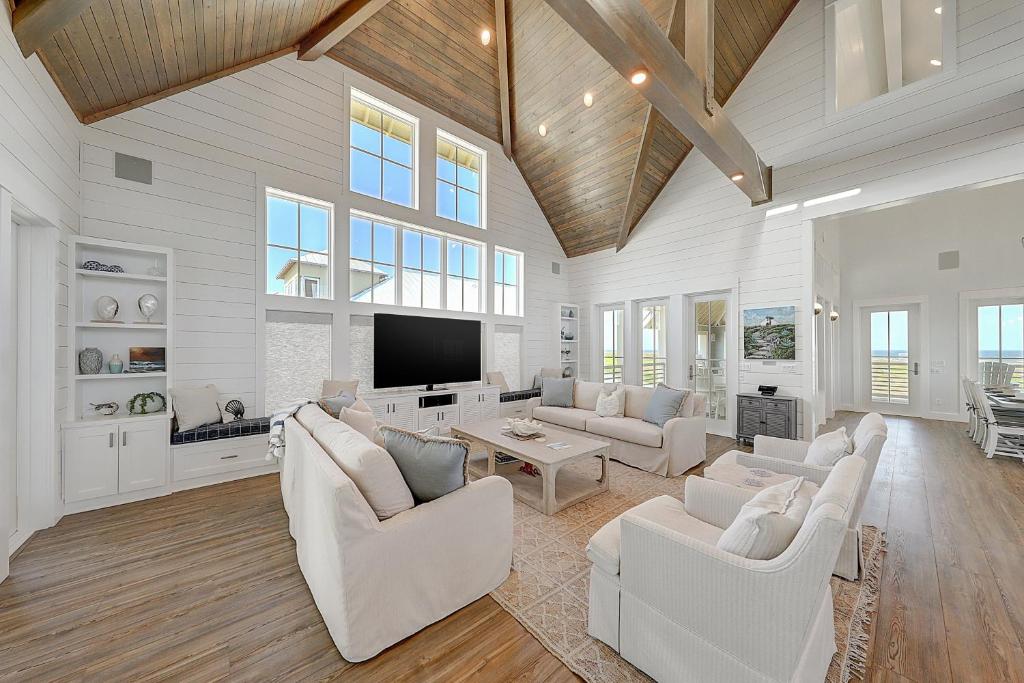 Una sala de estar con muebles blancos y un televisor de pantalla plana. en Seaside Paradise, en Mustang Beach