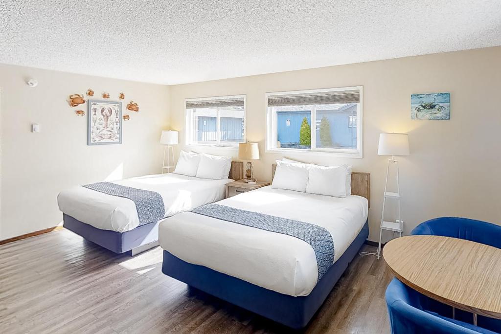 una habitación de hotel con dos camas y una mesa en Lamplighter Inn - 116 Crab Shack, en Bandon