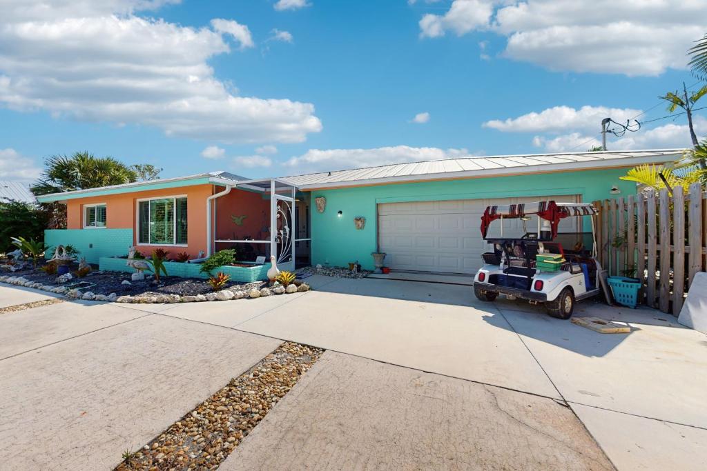 ein Haus mit einem davor geparkten Golfwagen in der Unterkunft Shell Seeker in Bowmans Beach Helistop