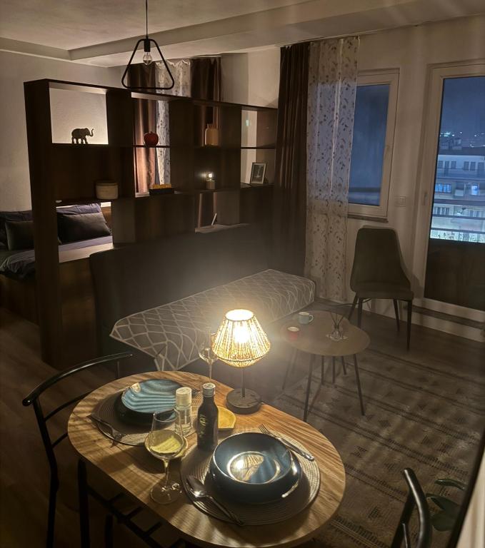 a room with a bed and a table with a lamp at Mimosa Apartments - City Center Square in Prishtinë