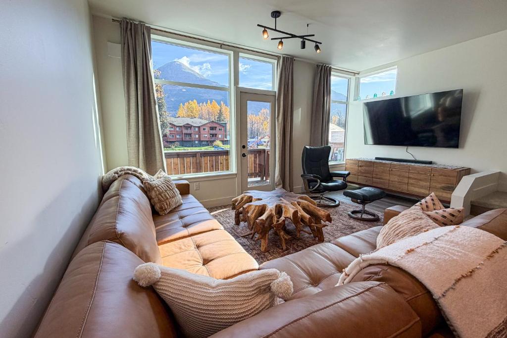 ein Wohnzimmer mit Couch und großem Fenster in der Unterkunft Silver Tip Condo in Girdwood Airport