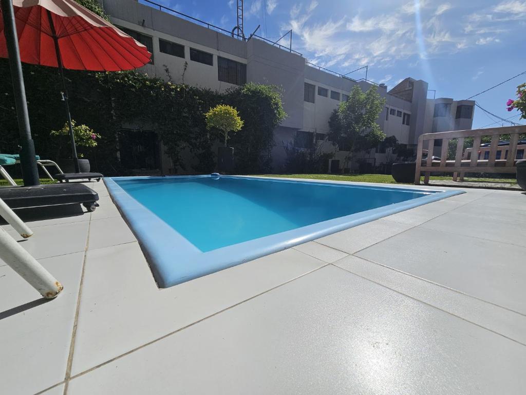 ein Swimmingpool mit Sonnenschirm neben einem Gebäude in der Unterkunft Rivero 520 in Arequipa