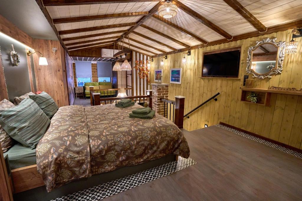 ein Schlafzimmer mit einem Bett und einem Fernseher in einem Zimmer in der Unterkunft Scandinavian Rustic in Tríkala