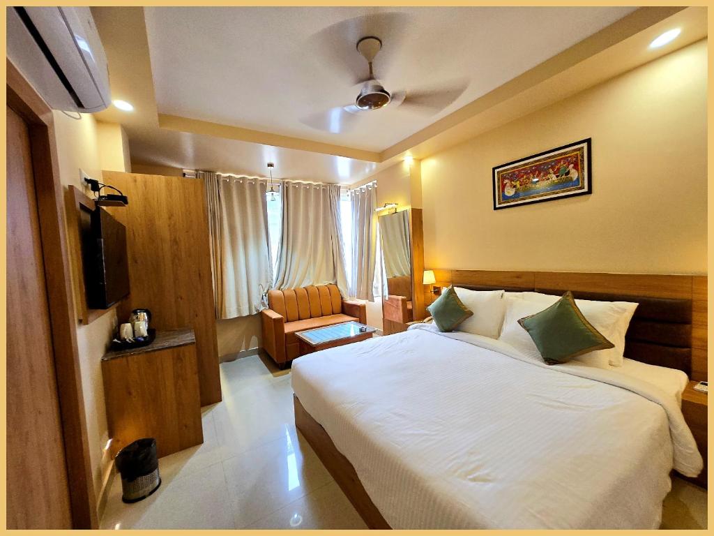 a hotel room with a bed and a chair at Rooftop SEA VIEW - SWIMMING POOL - Hotel The LB Resort Sea View Hotel Near Jagannath Temple - Parking And Resturent - Breakfast Included - A Fully Air Conditioning Luxuary Rooms - Top service in Puri