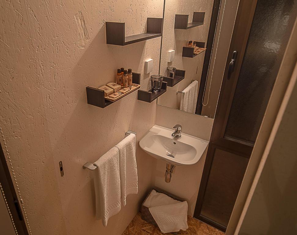 a small bathroom with a sink and a mirror at ALLuar Lodge in Angra do Heroísmo