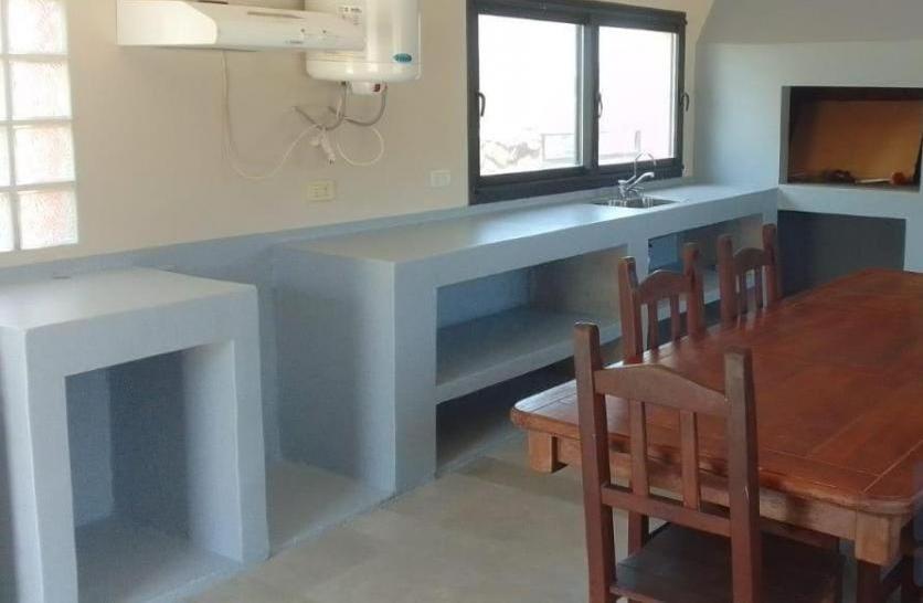 une cuisine avec une table et un évier et une table et des chaises dans l'établissement Vivaldi 192 Villa Carlos Paz, Córdoba, à Villa del Lago