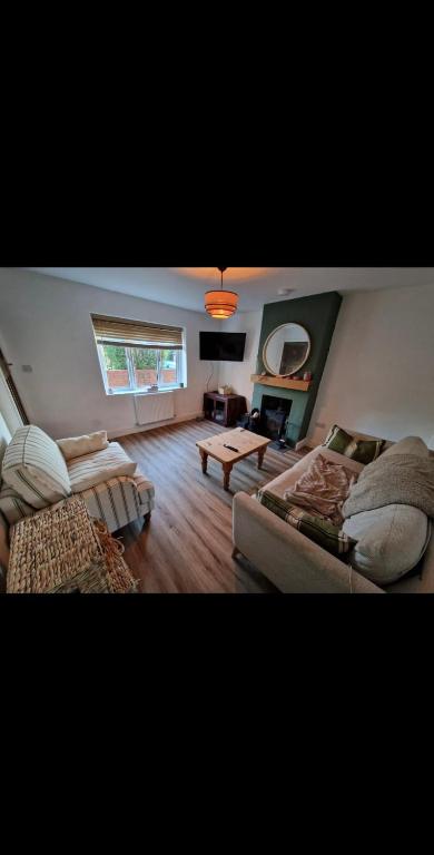 The Cosy House في ويلينغتون: غرفة معيشة مع أريكتين وطاولة