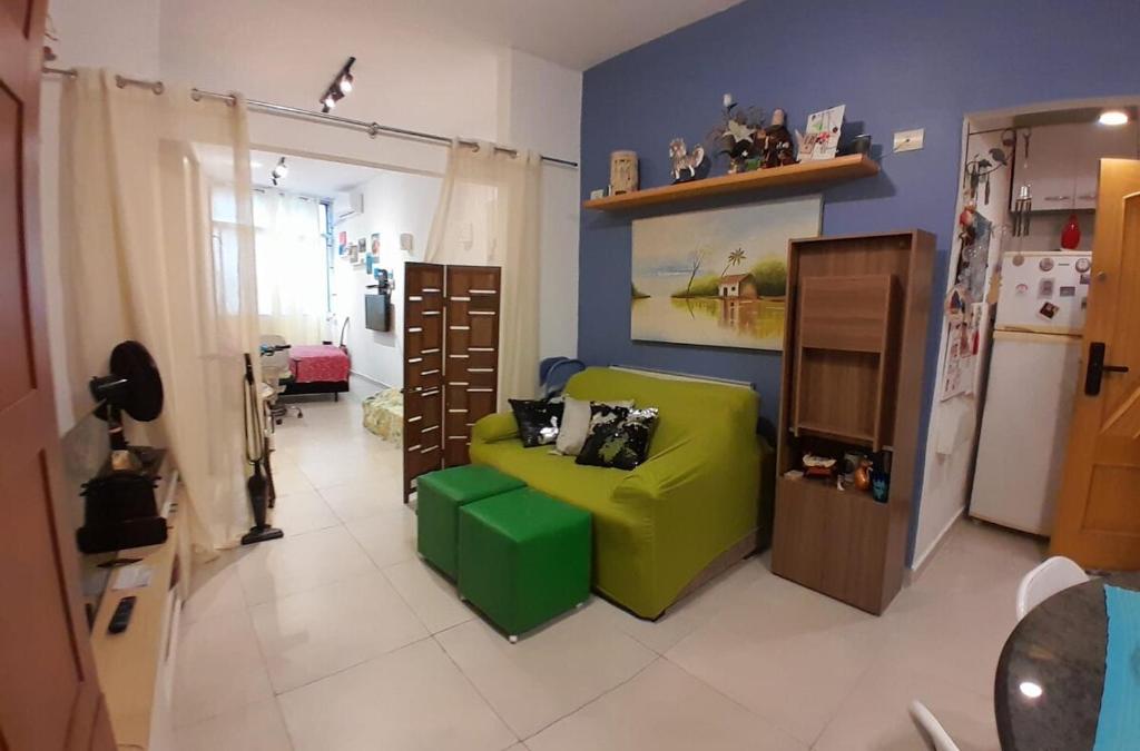 a living room with a green couch and a refrigerator at Angel's House Flamengo RJ in Rio de Janeiro