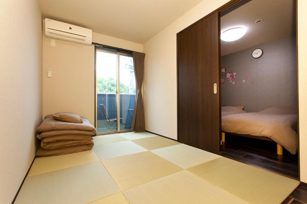 Habitación con 1 dormitorio con espejo y 1 cama. en Kyostay Iroha Toji Annex, en Kioto