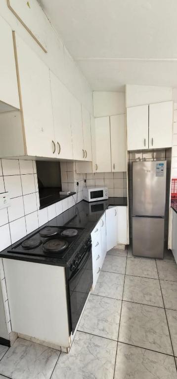 a kitchen with a stove and a refrigerator at 18 Laburnum Lodge in Durban