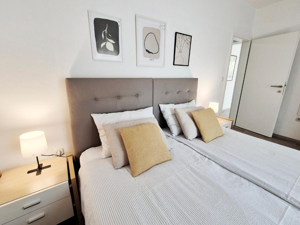 une chambre avec un grand lit avec des draps et des oreillers blancs dans l'établissement Apartments TENA with Private Parking, à Pula