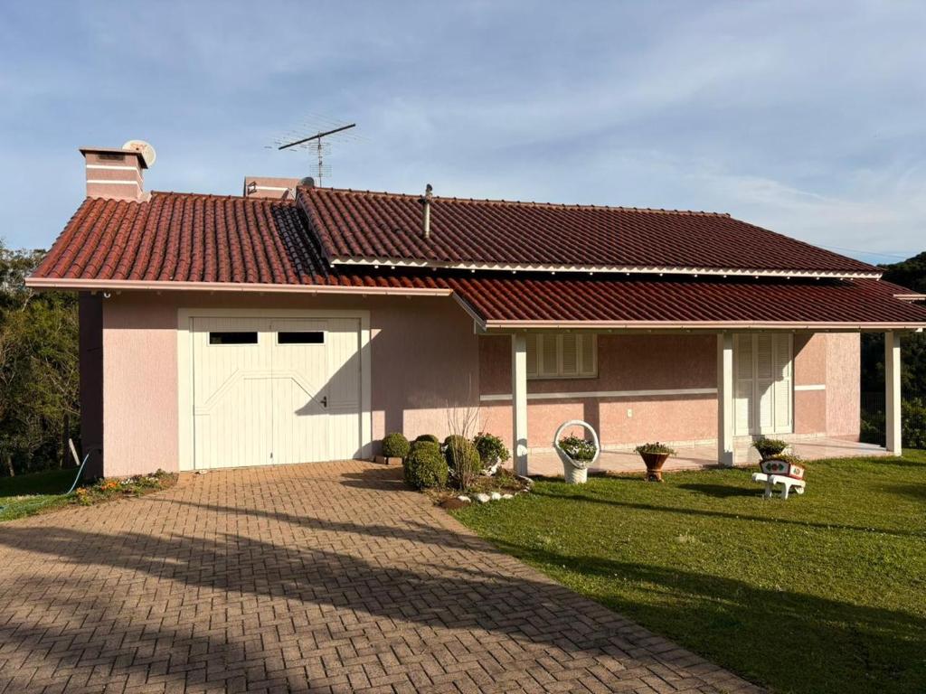 ein Haus mit einer gepflasterten Auffahrt davor in der Unterkunft Omma's Haus - Casa de Vó perto de Gramado in Morro Reuter