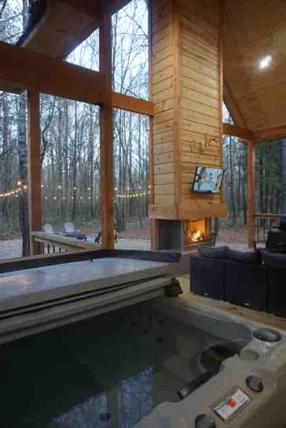 une table de billard dans une maison avec une cheminée dans l'établissement The Stunning Shady Creek Cabin, à Broken Bow