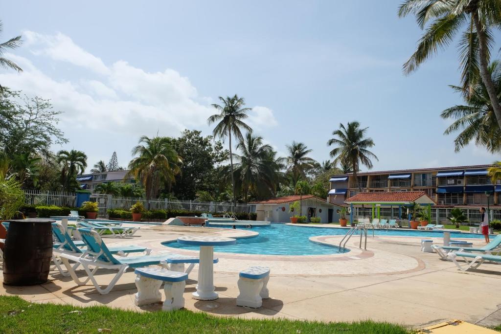 uma piscina com espreguiçadeiras e um resort em Paradigm Villa Dorado em Dorado