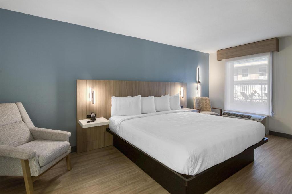 a bedroom with a large bed and a chair at Best Western Of Walterboro in Walterboro