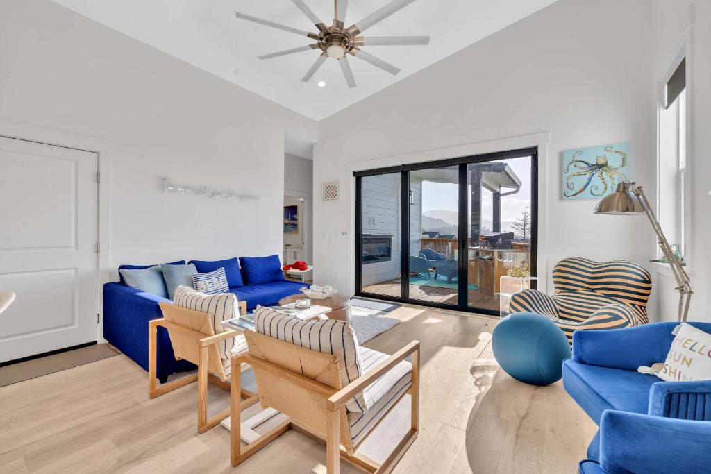 a living room with a blue couch and chairs at Deja View - Ocean View Neskowin Luxury in Neskowin