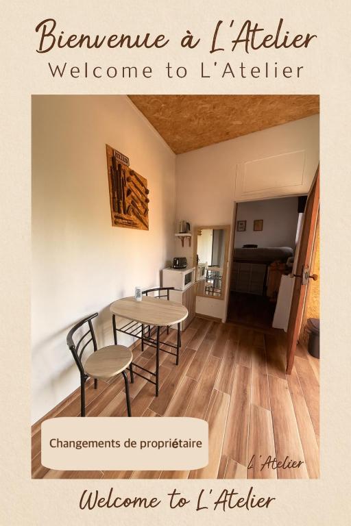 a room with a table and chairs and a kitchen at L'atelier in Festigny