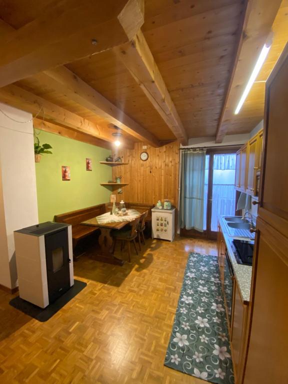 une cuisine avec une table et une cuisinière dans une pièce dans l'établissement Sole & Luna Dolomiti House, à Voltago