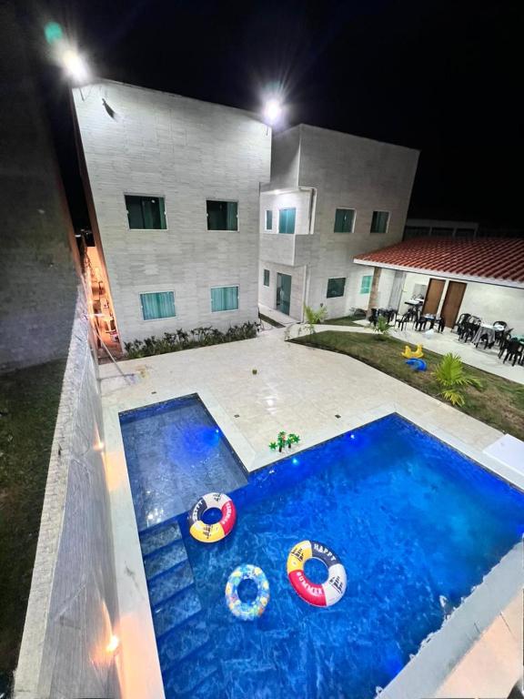 a house with a swimming pool at night at Sanzé Flats - São José da C Grande in São José da Coroa Grande