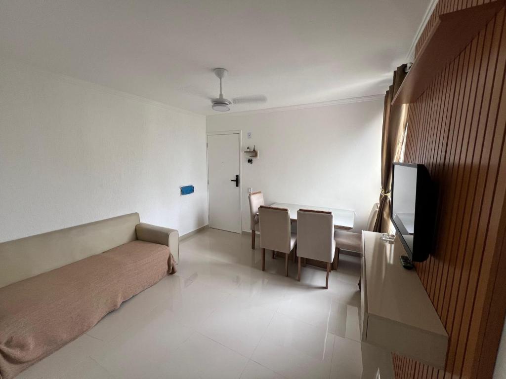 una camera con divano, tavolo e sedie di Ape 2 quartos a Guarujá