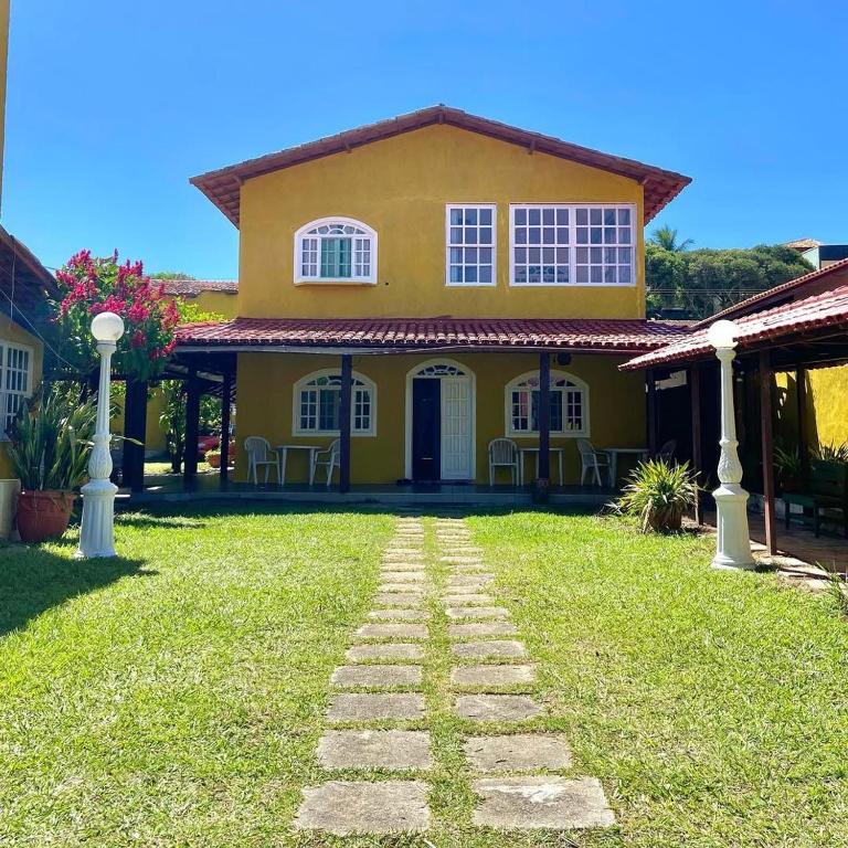 a yellow house with a pathway in front of it at Pousada Fonte da Samaritana in Vila Velha