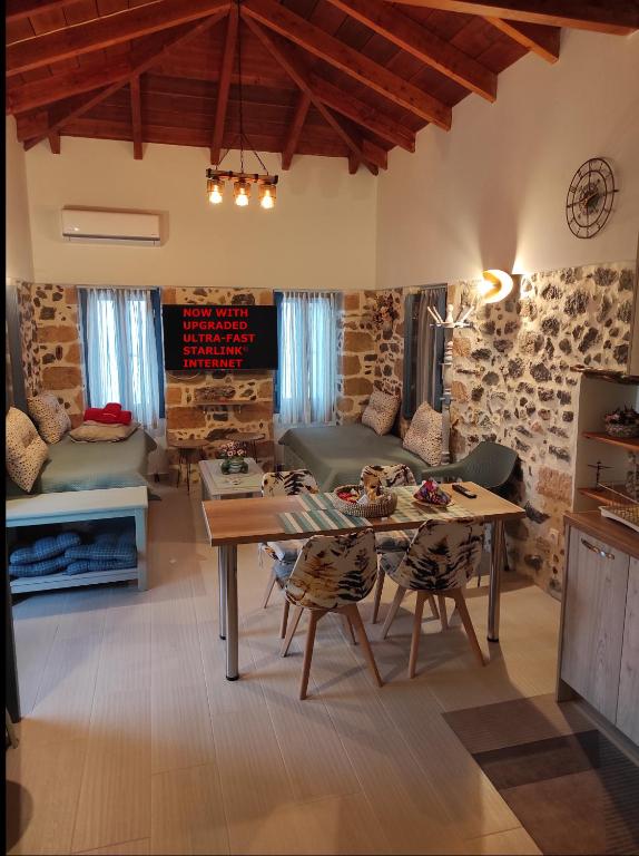a large living room with a table and chairs at To Pefko in Perdhika