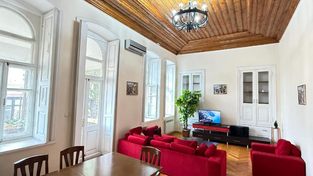 a living room with red furniture and a wooden ceiling at Old city apart in Baku