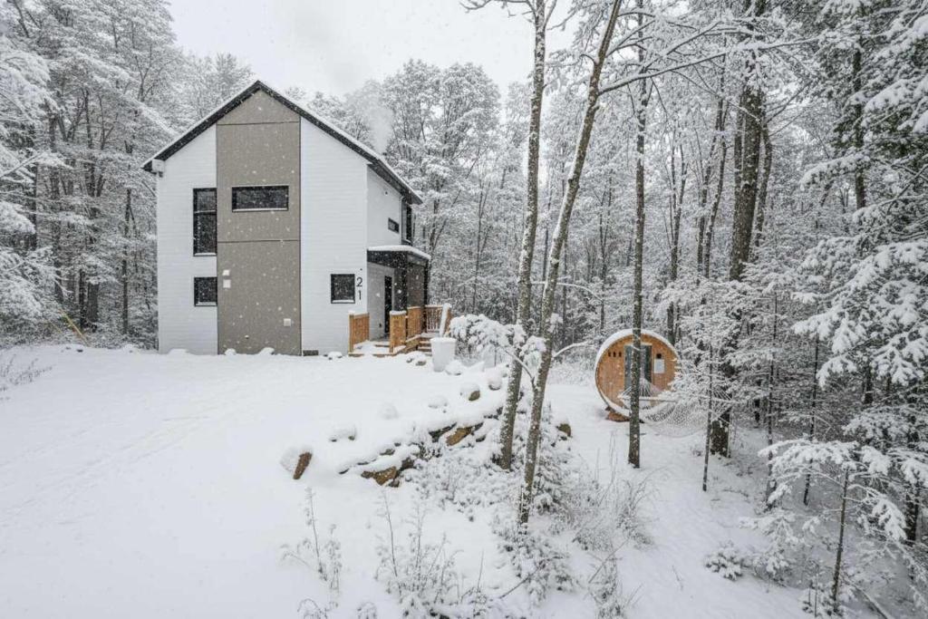 une petite maison dans la neige dans les bois dans l'établissement Le Soren, à Sainte Béatrix