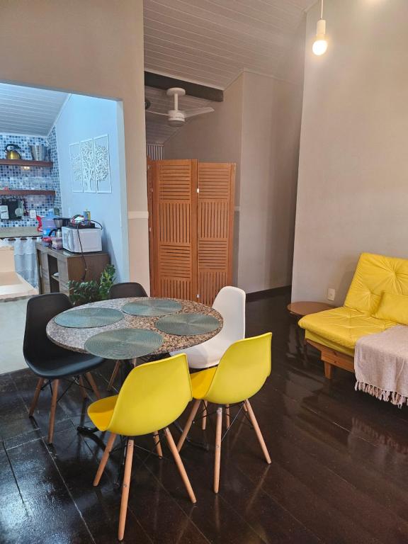 ein Esszimmer mit einem Tisch und gelben Stühlen in der Unterkunft Apart Coração de Búzios in Búzios