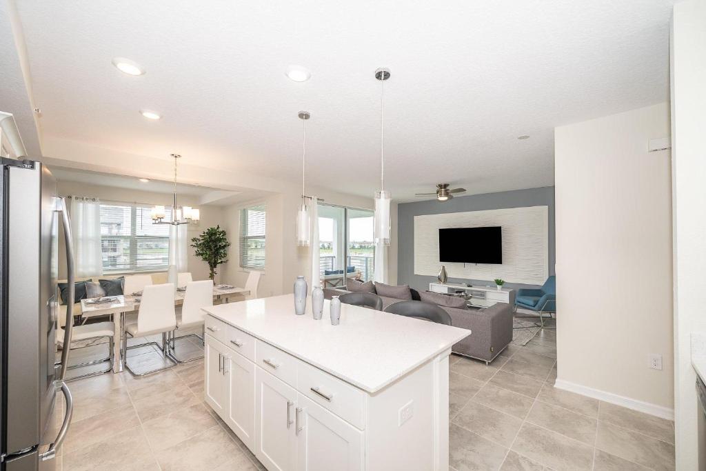 eine Küche und ein Wohnzimmer mit einer Couch und einem Tisch in der Unterkunft 3120-206DR STOREY LAKE, CONDO 2/2 GARDEN VIEW in Kissimmee