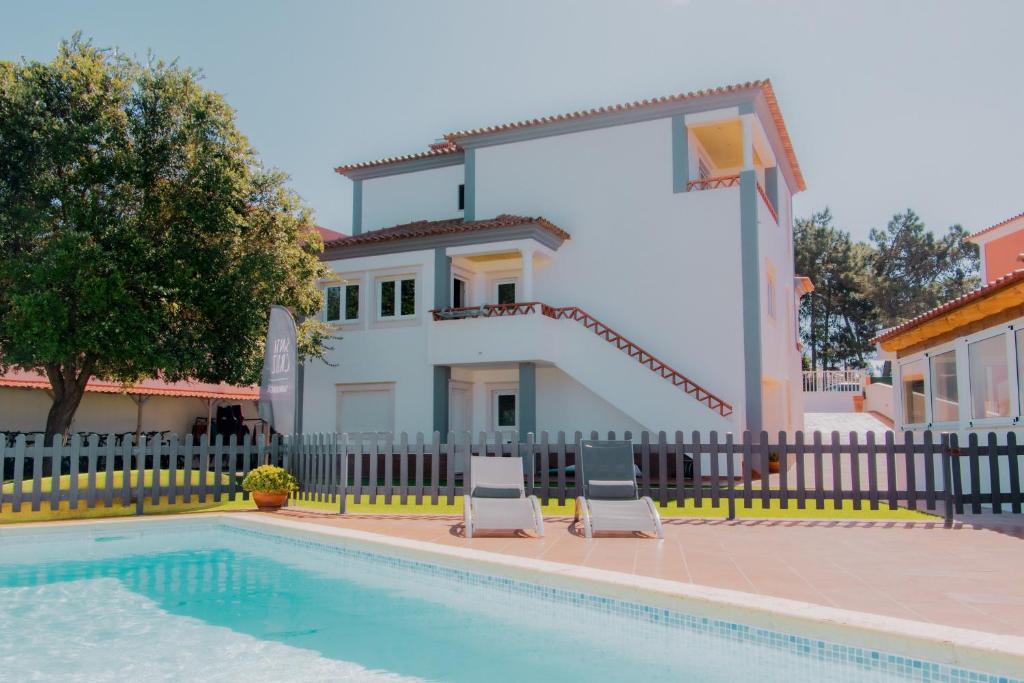 eine Villa mit Swimmingpool und ein Haus in der Unterkunft Surf Lodge Santa Cruz in Silveira