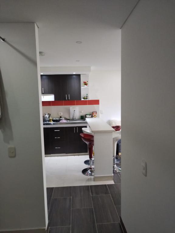 una cocina con armarios en blanco y negro y una mesa en Tranquilan-dias, en Guaduas