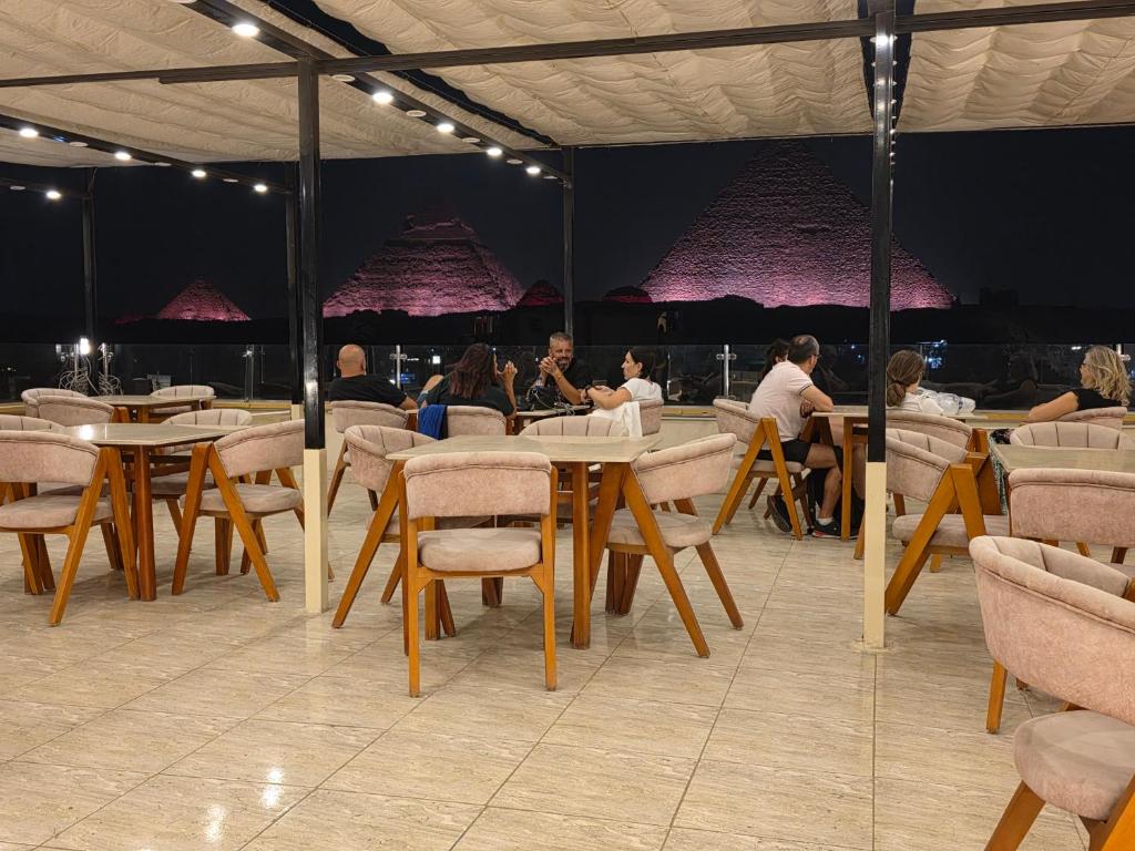 grupa ludzi siedząca przy stołach w restauracji w obiekcie Dyafa Pyramids Hotel & Spa w Kairze