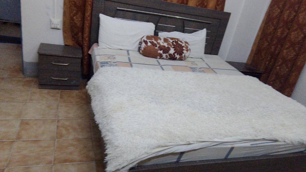 Una cama con una manta blanca y almohadas encima. en Hotel Al safa, en Hyderabad