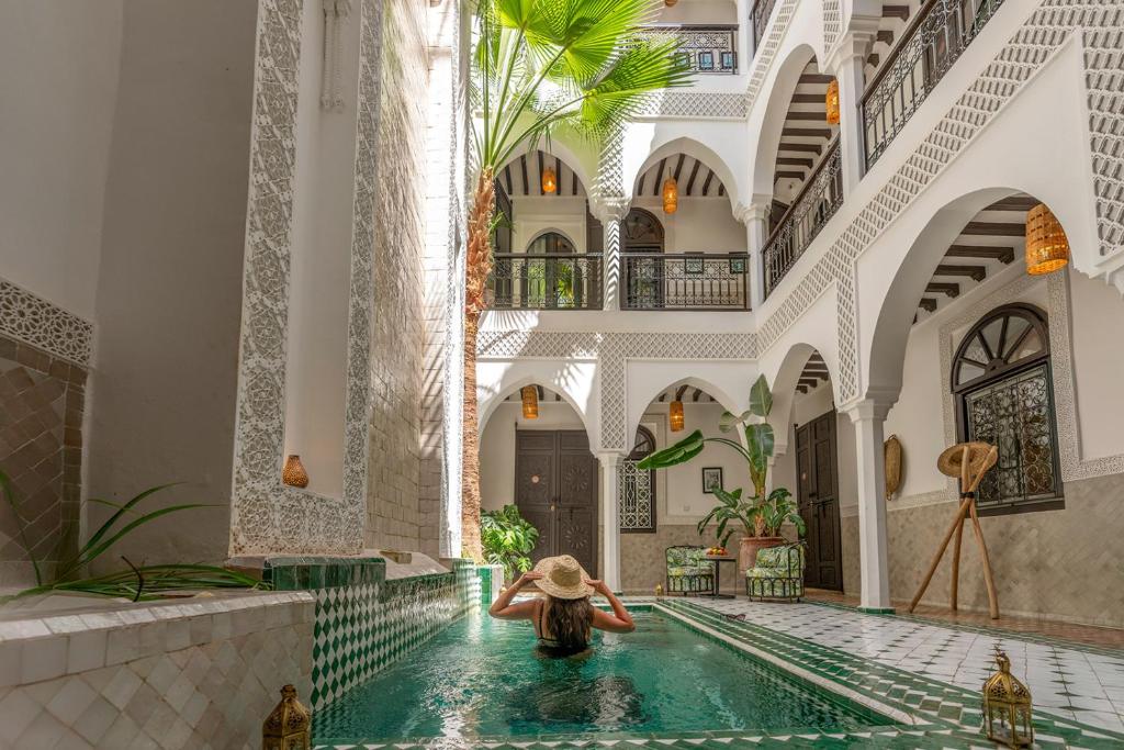 a woman in a swimming pool in a building at Riad NL&S Collection in Marrakech