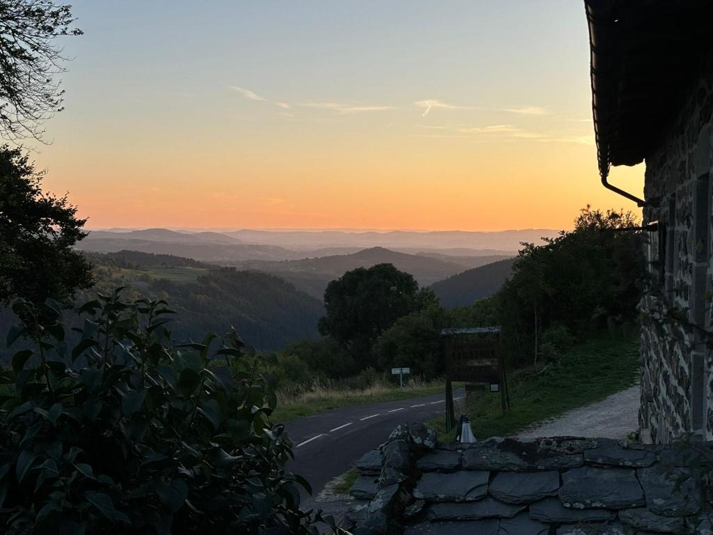 un camino vacío con la puesta de sol en el fondo en Auberge & Camping Sabatoux, en Montusclat