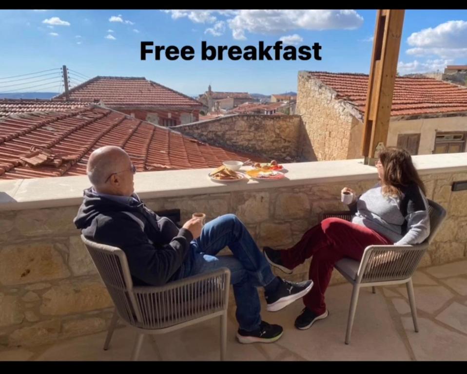 un hombre y una mujer sentados en sillas en un techo en Vouni Calais, en Vouni