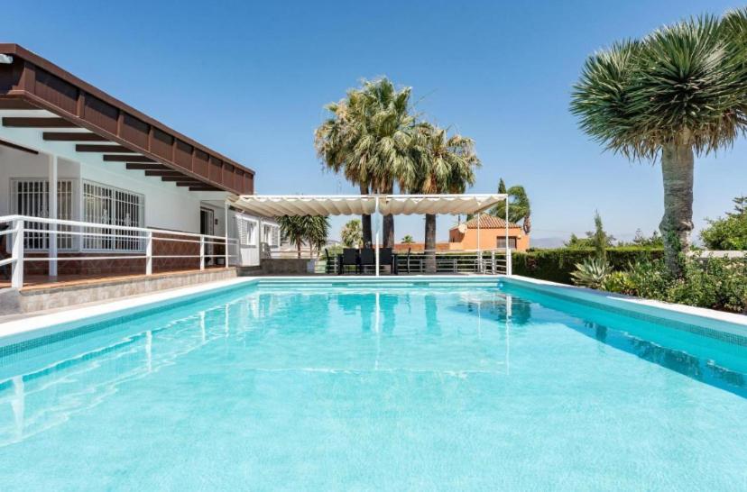 una piscina con acqua blu davanti a una casa di Villa Paula-Los Manantiales ad Alhaurín de la Torre