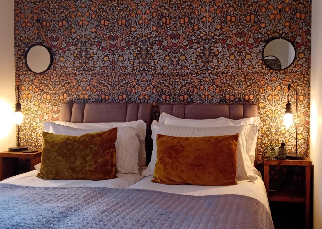 ein Schlafzimmer mit einem Bett mit zwei Kissen und einer Wand in der Unterkunft Executive Apartment nr NEC, BHX, Resorts World in Hampton in Arden