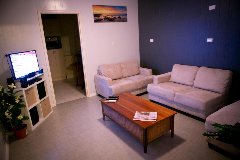 a living room with two couches and a coffee table at Cave Place Units in Coober Pedy