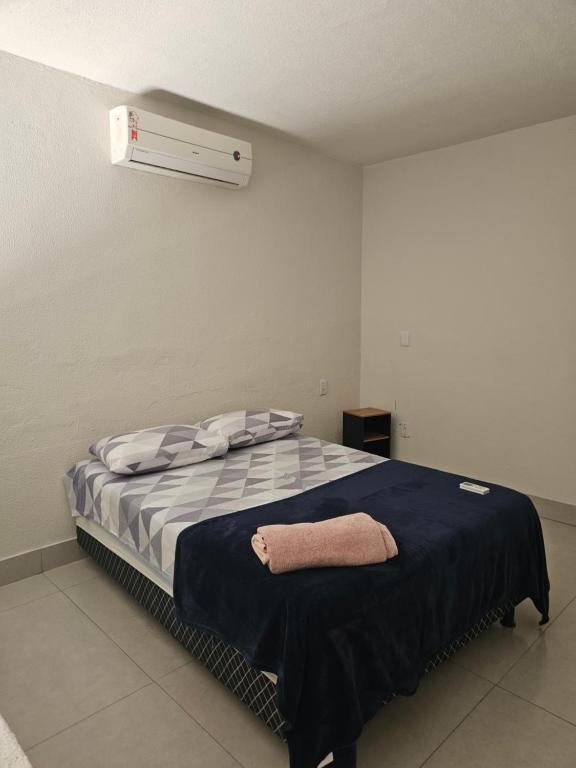a bedroom with a bed with a blue blanket at Apto Bell Valle I in Sorriso