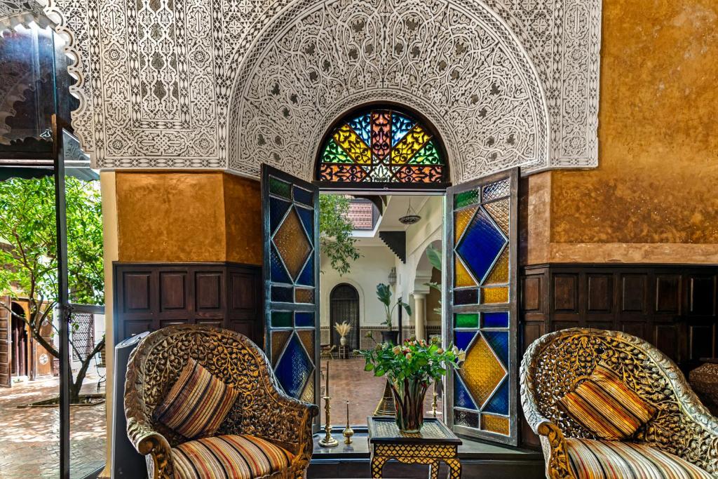 Una habitación con dos sillas y una vidriera. en Riad ILayka, en Marrakech
