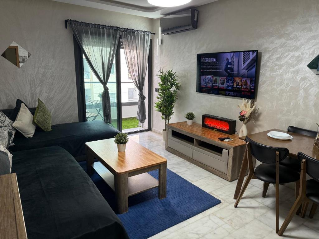 a living room with a couch and a tv on the wall at Studio Stadium morocco for family in Mohammedia